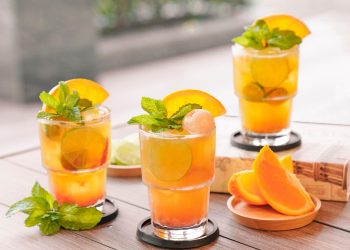 Refreshing citrus cocktails garnished with mint and orange slices.
