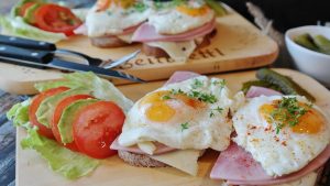 open-faced sandwich with eggs, ham, and vegetables