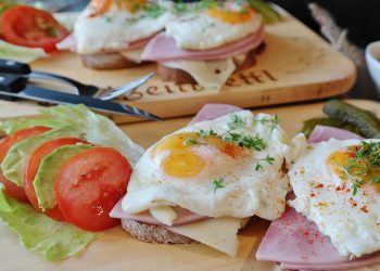 open-faced sandwich with eggs, ham, and vegetables