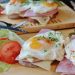open-faced sandwich with eggs, ham, and vegetables