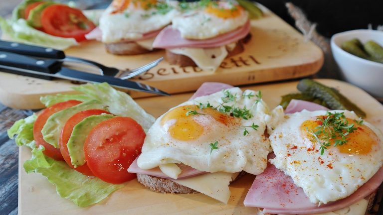 open-faced sandwich with eggs, ham, and vegetables