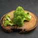 Fresh broccoli florets on a wooden board.