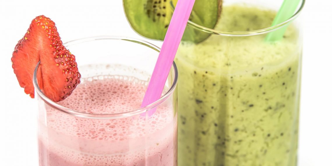 Strawberry and kiwi smoothies with colorful straws.