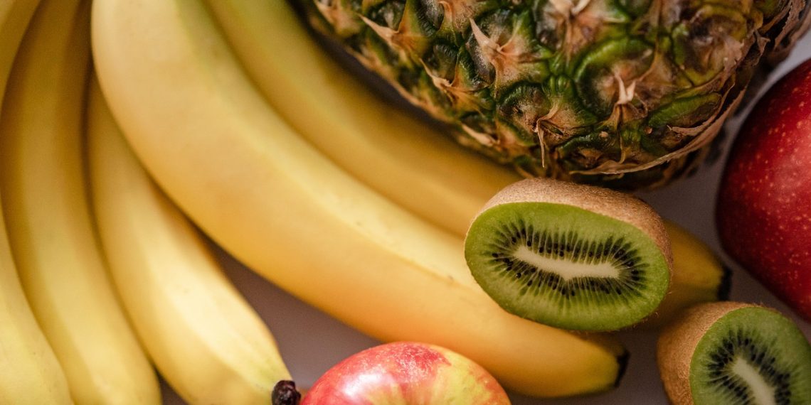 Bananas, kiwi, pineapple, and apple fruits displayed together.