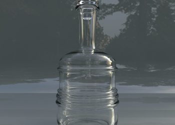 Glass decanter reflecting in low light setting.