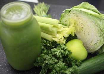 Green smoothie ingredients including celery, cabbage, apple, and greens.