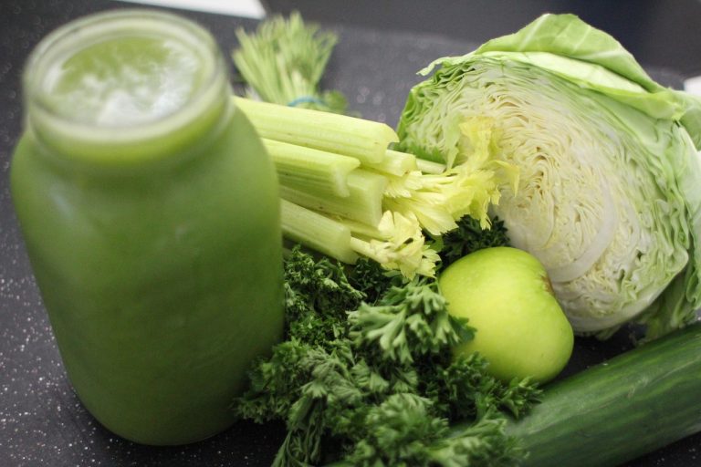 Green smoothie ingredients including celery, cabbage, apple, and greens.