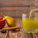 Pouring fresh pear juice with sliced apple and cinnamon.