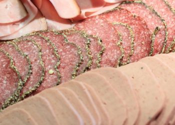 Assorted deli meats sliced thinly and neatly arranged.
