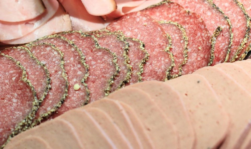 Assorted deli meats sliced thinly and neatly arranged.