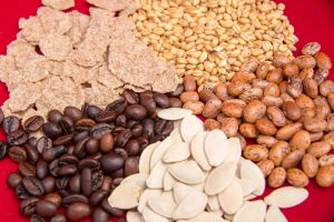 Assorted seeds and grains on red background.