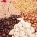 Assorted seeds and grains on red background.