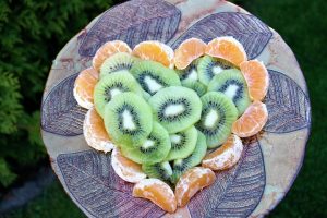 Kiwi and tangerine slices artfully arranged on a decorative platter.