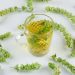 Greek mountain tea in glass mug surrounded by dried herbs.