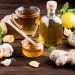 Herbal tea with ginger, garlic, lemon, and honey on wooden table.