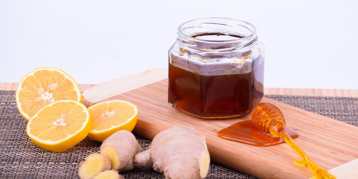Lemon, ginger, and honey on a wooden platter for a natural remedy.