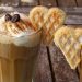 Cinnamon-topped latte with whipped cream and heart-shaped waffles.