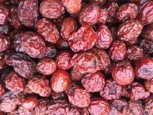 Dried red jujubes in a heap, showcasing their rich texture and vibrant color.