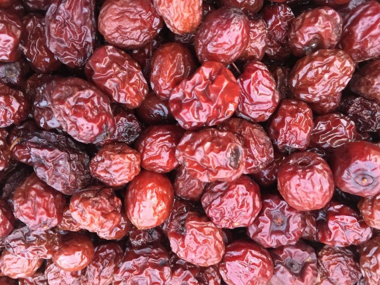 Dried red jujubes in a heap, showcasing their rich texture and vibrant color.