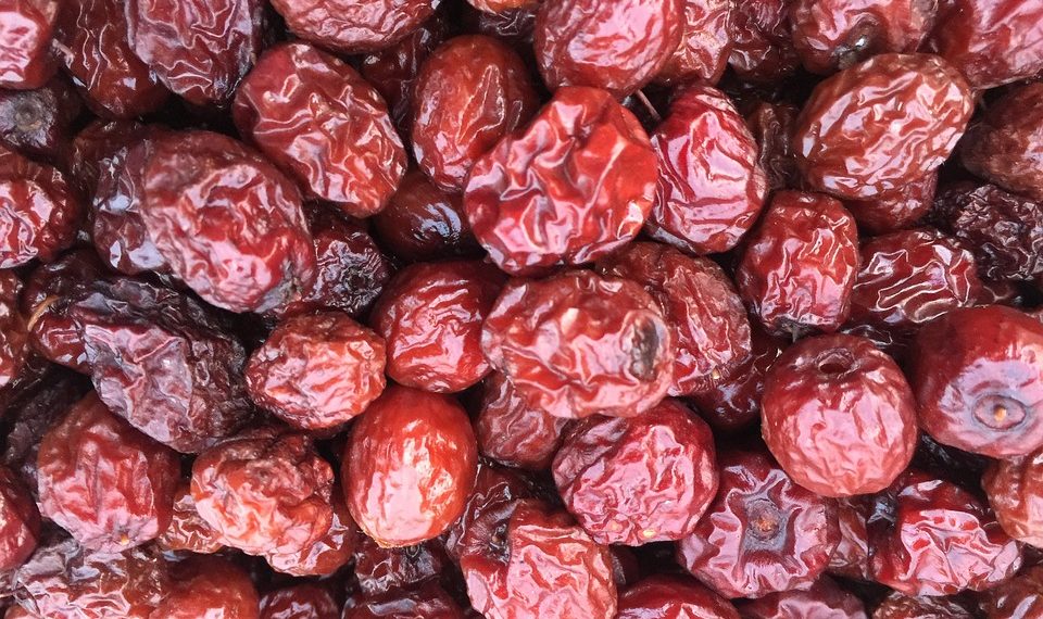Dried red jujubes in a heap, showcasing their rich texture and vibrant color.