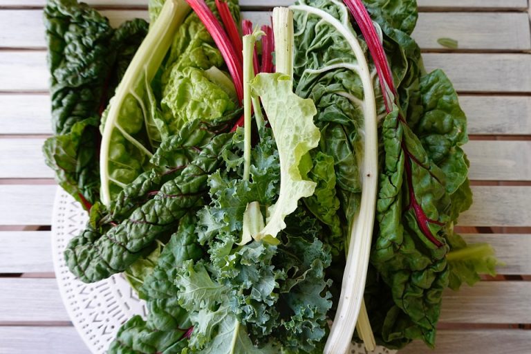 Fresh leafy greens on a wooden table.