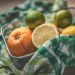 Mixed citrus fruits in a basket with colorful checkered cloth.