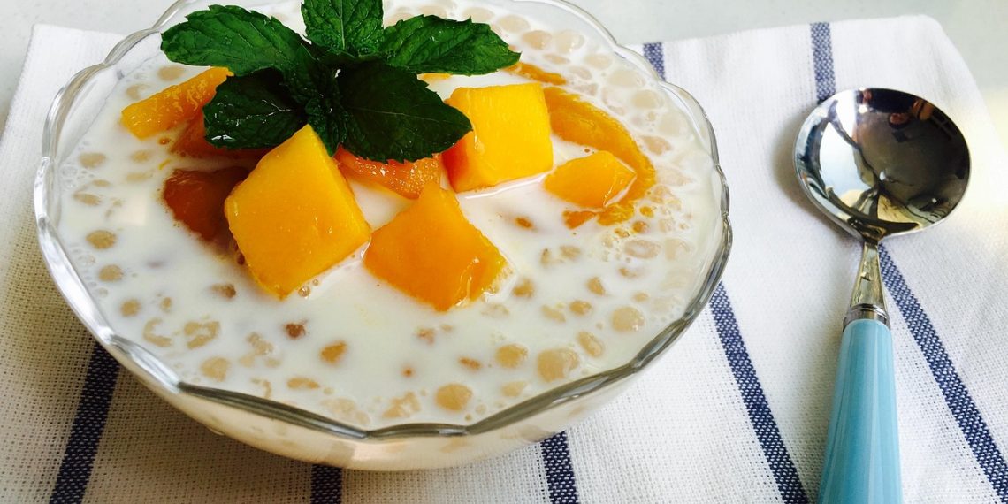 Creamy tapioca pudding topped with mango and mint leaves.