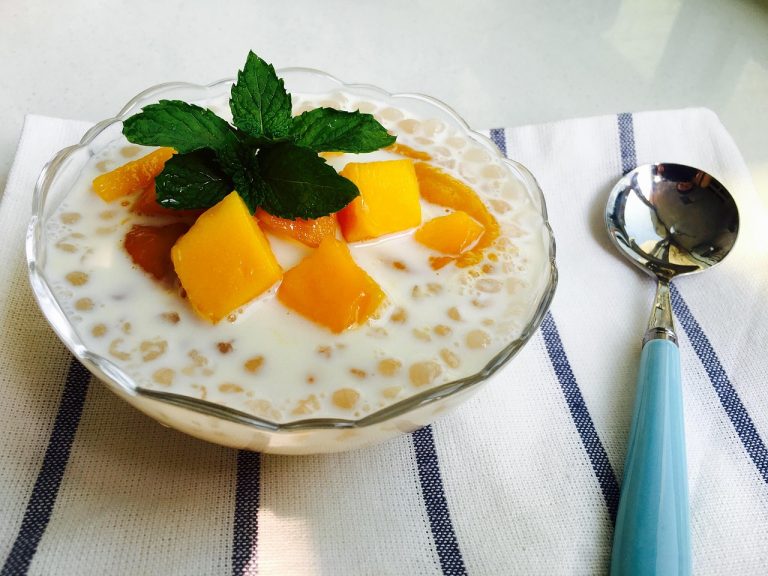 Creamy tapioca pudding topped with mango and mint leaves.