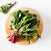 Fresh Swiss chard on a wooden cutting board.