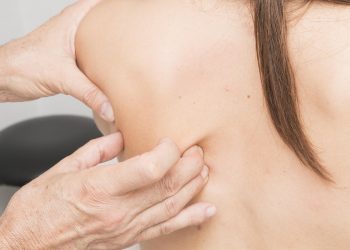 Chiropractor performing shoulder adjustment therapy.