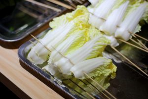 Napa cabbage skewers prepared on a tray for grilling.