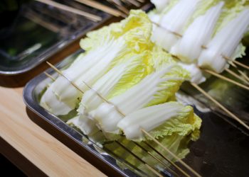 Napa cabbage skewers prepared on a tray for grilling.