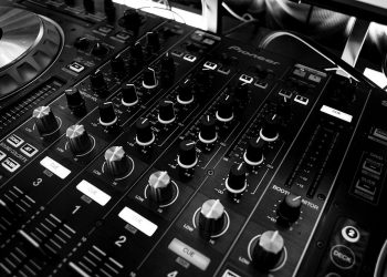DJ mixing console with multiple controls and dials, used for music production.