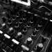 DJ mixing console with multiple controls and dials, used for music production.