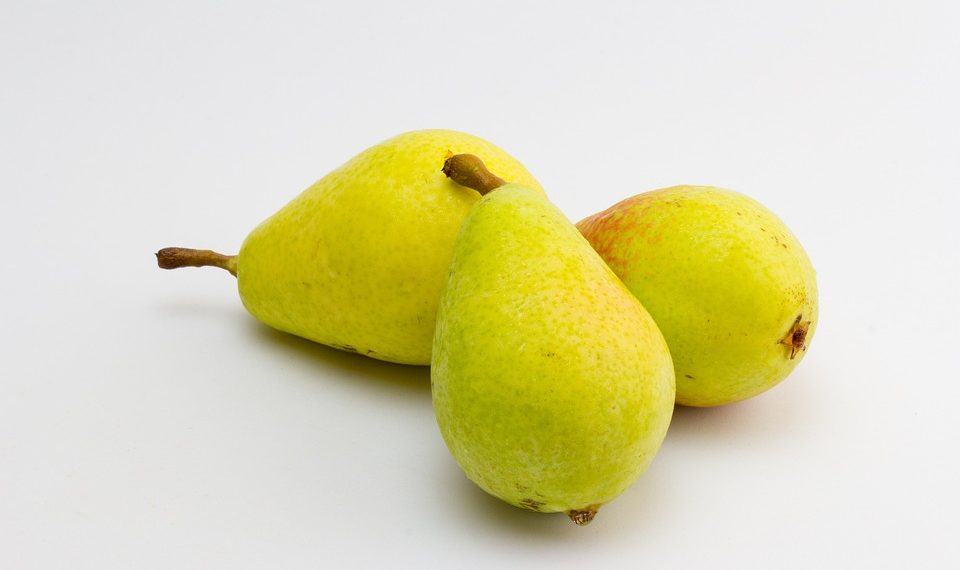 Three fresh yellow pears on a white background.
