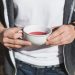 Hands holding a cup of red tea outdoors