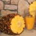 Pineapple juice in glass with fresh pineapple slice.