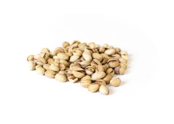 Pile of roasted pistachios on white background.