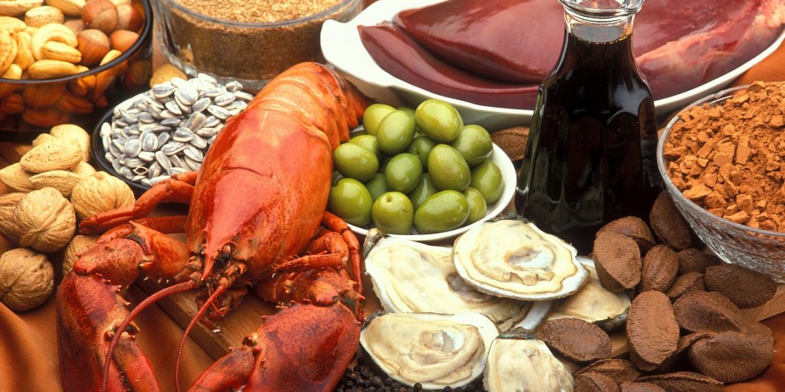 Assorted seafood, nuts, and olives with oil displayed on a table.