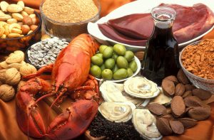 Assorted seafood, nuts, and olives with oil displayed on a table.
