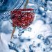 Strawberry with bubbles submerged in water.