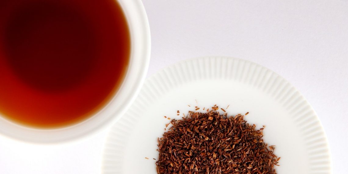 Brewed rooibos tea with loose leaves on a plate.