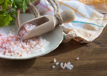 Pink Himalayan salt in wooden scoop on the table.