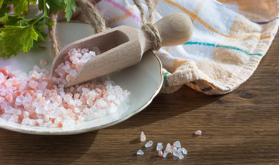 Pink Himalayan salt in wooden scoop on the table.