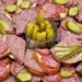 Open sandwiches with salami and pickles arranged on a platter.