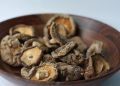 Dried shiitake mushrooms in a wooden bowl.