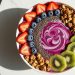 Berry smoothie bowl with kiwi, strawberries, blueberries, granola, and chia seeds.