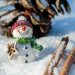 Snowman figurine with gingerbread in snowy setting.