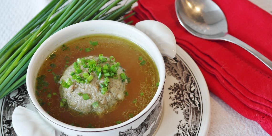 Herb dumpling soup with chives and red napkin.