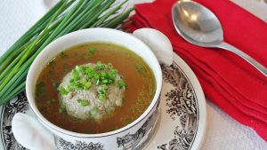 Herb dumpling soup with chives and red napkin.